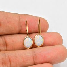 Natural Australian Opal Earrings (Pair) ✪Gemstone: Natural Australian Opal  ✪Metal: 18k solid Yellow gold. ✪Stone size: 6x8 mm. ✪Stone Shape :Oval  ✪Stone Weight : 2 Ct. ✪ Earring Weight : 1.25 Gram ✪Earring Length : 25 mm. ✪Earring width : 7 mm. ✪Setting type: Bezel wire setting. If you need any other preferred stone please contact us. Opal benefits - *The stone is believed to counteract bad effects and bring prosperity, beauty, love, and romance in like.  *It brings success in dating and benefits those who are in dairy and hospitality industry. *Opal gemstone benefits include enhancing joy in marital life.   QUALITY OF MATERIALS: Metal: Most of our jewelry at JewelryMansion is made with precious metals like gold and silver. These metals are 100% non-allergic to our skin. Gemstone: All of Fine Jewelry Opal Earrings For Gift, Oval Opal Earrings In Yellow Gold, Gold Ethiopian Opal Earrings For Gift, Yellow Gold Oval Opal Earrings, Elegant Ethiopian Opal Earrings As Gift, Opal Earrings With Ear Wire For Gift, Opal Yellow Gold Earrings For Gifts, Opal Ear Wire Earrings For Gift, Yellow Gold Opal Earrings Gift