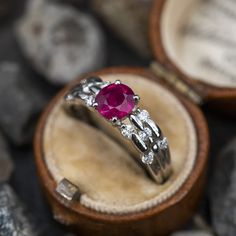 This stunning ring is centered with one (1) oval mixed cut natural ruby weighing 1.05 carats and set into a four-prong head. The shoulders of the ring are each accented with five (5), channel set, round brilliant cut diamonds. The ring measures 6.2mm at the top, rises 5.1mm above the finger, tapering to 2.6mm wide and 1.7mm thick at the base of the shank. This ring is currently a size 6.25. Classic Diamond Ring With Lab-created Ruby Accent Stones, Ruby Diamond Ring With Accent Stones And Round Cut, Classic Ruby Ring With Diamond Accent Stones, Ruby Ring With Accent Stones In Platinum, Platinum Ruby Ring With Accent Stones, Ruby Wedding Ring With Round Cut And Accent Stones, Fine Jewelry Ruby Ring With Accent Stones In Platinum, Lab-created Ruby Ring With Brilliant Cut In Oval Shape, Fine Jewelry Diamond Solitaire Ruby Ring