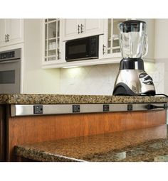 a blender sitting on top of a kitchen counter next to a microwave and oven