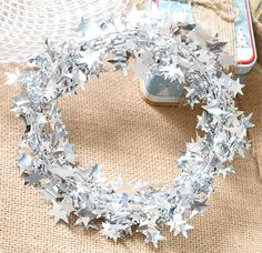 a tinsel wreath with silver stars on it next to an open can of toothpaste