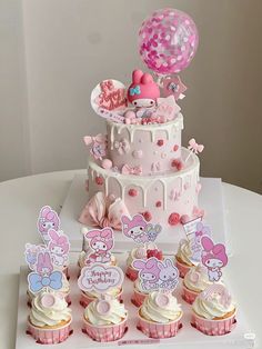 a birthday cake and cupcakes on a table