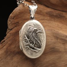 "Whimsigothic jewelry locket with working compass inside and a place for your favorite photo. Sterling silver nature necklace with working compass, and a Raven sitting on a branch: a mini working brass compass with glass top is set inside a sterling silver ring. The working compass is set inside a .925 sterling silver oval locket. On the front of the etched locket is a raven sitting on a branch in sterling silver. A picture locket necklace with working compass for the gardener, nature lover, bir Whimsigothic Jewelry, Silver Gothic Jewelry For Costume, Handmade Antique Silver Locket Necklace, Handmade Antique Silver Pendant Locket Necklace, Antique Silver Jewelry For Halloween Gift, Gothic Antique Silver Jewelry For Gift, Gothic Round Engraved Necklaces, Vintage Silver Jewelry For Costume Or Role-play, Handmade Gothic Jewelry In Antique Silver