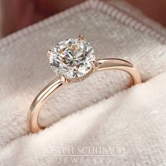 a close up of a diamond ring on a white blanket