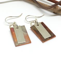 if you are looking to add a special touch to your outfit or need a unique gift, these handmade copper and sterling silver dangle earrings would be perfect. Because of their rich colors and smooth design, these earrings are great to wear to go out with friends or at work, making you feel wonderful and stylish. These earrings are perfect to indulge yourself or as a gift to give joy to someone else for their birthday, graduation, Mother's Day, Christmas, or just to show her some love! The copper on these earrings has been treated with heat bringing unique colors to the rectangle making each one different and allowing the copper not to tarnish, because of this no one earrings will have the same colors. The sterling silver rectangle has been textured. Each piece is handmade by me. The drop leng Patina Earrings, Rustic Earrings, Yellow Room, Mixed Metal Earrings, Copper Patina, Sterling Silver Dangle Earrings, Unique Handmade Jewelry, Handmade Copper, Metal Earrings