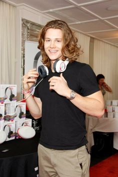 a man is holding up headphones at an event