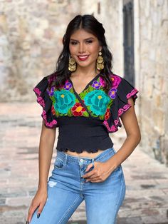 This beautiful Butterfly Sleeve Crop Top is the perfect Top for a fun day out or special event. The adorable fluttery sleeves and colorful embroidered flowers make it flirty and fun. It's made out of cotton, has an elastic waist and has colorful flowers embroidered by Artisanal Machine. This blouse is made with love by Mexican Artisans in Chiapas, Mexico. Purchase the gold plated filigree earrings here: https://www.etsy.com/es/listing/870716921/aretes-mexicanos-de-filigrana-aretes?ref=listings_m Multicolor V-neck Top With Floral Embroidery, Embroidered V-neck Festival Top, Fitted V-neck Blouse With Multicolor Embroidery, Fitted Multicolor Top With Floral Embroidery, Fitted Multicolor Tops With Floral Embroidery, Fitted Embroidered Multicolor Tops, Mexican Blouse Outfit, Top Mariposa, Low Cut Crop Top