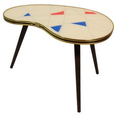 a white table with blue, red and yellow shapes on it's top is shown