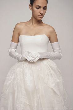 a woman wearing white gloves and a dress