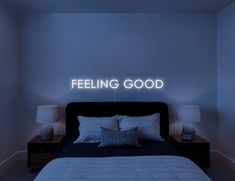 a bed sitting in a bedroom under a neon sign that says feeling good on the wall