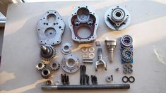 an assortment of parts are laid out on a table to be used as part of a motorcycle engine