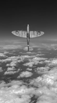 an airplane flying above the clouds in black and white