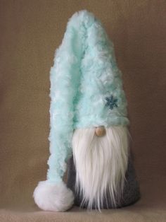 a stuffed gnome is wearing a blue and gray hat with white fur on it's head