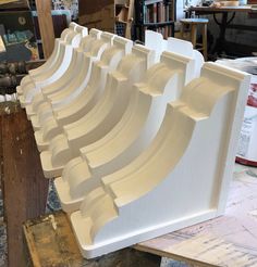 a row of white shelves sitting on top of a wooden table