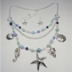 This Beautiful Rhodium Nautical Starfish Seashell Aqua And Blue Beads Sea Life Layered Necklace And Earrings Set Features Aqua, Blue And Rhodium Beads With The Rhodium Sea Horse, Seashells, Sand Dollar And Starfish Charms As Well As Aqua And Blue Beads And Bluish Pearls. The Silver Tone Necklace Is 20 Inches Long With A 2 Inch Extender To 22 Inches And Has A Lobster Claw Clasp For A Secure Fit On Your Neck. The Starfish Pendant Measures 1 1/2 Inches High And 1 1/2 Inches Wide. Cn 5-0032 Adjustable Blue Starfish Jewelry, Adjustable Blue Jewelry With Starfish Charm, Bohemian Blue Jewelry With Starfish Charm, Bohemian Blue Starfish Charm Jewelry, Ocean-inspired Beaded Jewelry, Beach Dangle Beads Jewelry, Blue Multi-strand Jewelry With Dangling Beads, Bohemian Starfish Jewelry With Lobster Clasp, Bohemian Starfish Charm Jewelry For Jewelry Making