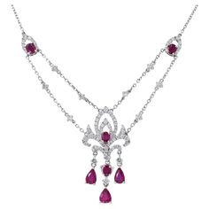 Presenting our stunning 18KT White Gold Genuine Ruby and Diamond Drop Necklace, a masterpiece of elegance and sophistication. This exquisite necklace showcases the beauty of genuine Burmese rubies, featuring a total of 2.25 carats of pear and oval-cut rubies. These radiant gemstones are beautifully complemented by 1.26 carats of round-cut diamonds, which boast G color and VS1-VS2 clarity. The result is a truly captivating piece of jewelry that exudes luxury and grace. Length 17 inches. Weight 9. Luxury Ruby Necklace With Brilliant Cut, Fine Jewelry Ruby Diamond Necklace Brilliant Cut, Formal Ruby Diamond Necklace With Brilliant Cut, Luxury Ruby Necklace With Diamond Accents, White Gold Ruby Necklaces With Brilliant Cut, White Gold Ruby Necklace With Brilliant Cut, Luxury Ruby Necklaces With Diamond Accents, Luxury Ruby Diamond Necklace With Accents, Luxury Ruby Diamond Necklace With Diamond Accents