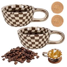 two coffee mugs and some beans on a white surface with brown circles around them