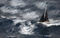 an aerial view of a sailboat in the ocean with water splashing around it