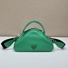 SHOP MORE LUXURY PRODUCTS HERE Description Prada Triangle Bag Green For Women, Women’s Bags 9.8in/25cm 1BB082_2BYA_F0458_V_NEO This soft bag reinvents in an innovative way the classic and sophisticated shape of the top-handle bag, transforming it into a versatile, sporty design. The accessory with double handle and detachable logo-print woven tape shoulder strap can be worn in different ways and is decorated with a modern interpretation of the lettering logo appearing as an embossed detail Cm Logo, Tape Shoulder, Prada Triangle, Triangle Bag, Embroidered Handbag, Soft Leather Bag, Soft Bag, Sporty Design, Lettering Logo