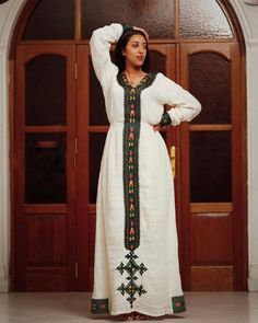 This Habesha Kemis is a true work of art, crafted from handwoven Axum fabric that showcases the rich cultural heritage of Ethiopia. The intricate patterns and vibrant colors of the fabric are a testament to the skill and artistry of the weavers, creating a mesmerizing and eye-catching effect. The dress is expertly crafted with intricate details that highlight the beauty of the wearer, from the flowing sleeves to the elegant neckline. The simple and elegant design of the dress allows the handwove Traditional Long Handloom Dress, Traditional Handloom Festival Dress, Traditional Long Sleeve Dress With Weaving Work, Bohemian Ceremonial Dresses With Woven Motifs, Traditional Dresses With Multicolor Embroidery And Woven Motifs, Embroidered Dress With Traditional Patterns For Eid, Folk Style Embroidered Dress For Festive Season, Habesha Kemis For Eid With Traditional Patterns, Eid Habesha Kemis For Traditional Ceremonies