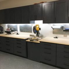 a kitchen with black cabinets and white counter tops