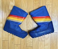 Super cool pair of vintage 1960s / 1970s moon boots / puffy boots / Winter boots / chateau Après-Ski boots.  Rich blue shade with a graphic colorway / colorblock rainbow chevron stripe in red - gold - yellow - light blue.  Great chunky & thick rubber tread sole. Has original matching blue laces; would also look cute with contrast color laces in yellow, red, etc.!  Vintage size tag is faded but reads 8-10 (see pic). I'm a size 8 and comfortably fit in them with medium weight socks they're a solid size 8. They might also work for a larger size but see outer sole measurements below to be sure. Bottom Sole Measurments:  Length: 10" Width (at widest point): 4" 💥Condition: Great worn condition. One small triangular piece is missing from the top inner part of one boot. The tread sole needs more Retro High-top Winter Boots, Puffy Boots, Apres Ski Boots, Rainbow Chevron, Boots Winter, Moon Boots, Chevron Stripe, Yellow Light, Ski Boots