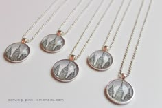 four necklaces with pictures of buildings on them