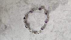 Elevate your style with the timeless elegance of this Genuine Amethyst and 925 Sterling Silver Bracelet, measuring 7 inches in length. Crafted with care, this bracelet showcases the natural beauty of amethyst stones, each carefully set in sterling silver. Whether as a gift for a loved one or a treat for yourself, its handmade design adds a personal touch, making it a perfect accessory for any occasion. Embracing the latest trends with a boho-chic flair, it effortlessly captures the essence of mo Wedding Sterling Silver Adjustable Bracelet, Handmade Classic Wedding Bracelets, Classic Handmade Wedding Bracelets, Classic Sterling Silver Crystal Bracelet For Wedding, Elegant Amethyst Bracelets For Wedding, Elegant Adjustable Stamped 925 Chain Bracelet, Elegant Adjustable 925 Stamped Chain Bracelet, Amethyst Bracelet For Weddings, Sterling Silver Crystal Gemstone Bracelet For Wedding