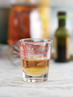 a shot glass filled with liquid sitting on top of a counter