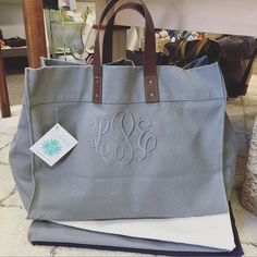 a gray tote bag with two monogrammed initials on it