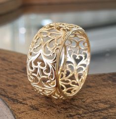 two gold rings sitting on top of a wooden table