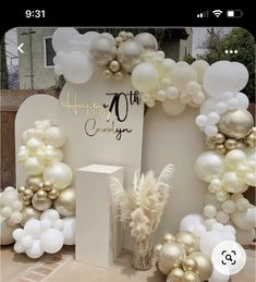 a table topped with balloons and white flowers next to a sign that says happy 50th