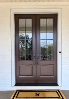 the front door is brown and has two glass doors