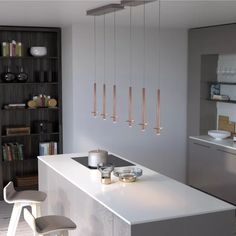 a modern kitchen with white counter tops and gold accents, along with bar stools