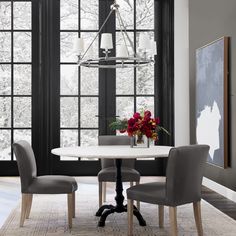 a dining room table with four chairs and a chandelier hanging from the ceiling