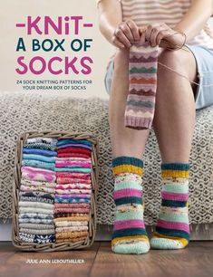 a woman sitting on top of a couch next to a pile of knitted socks