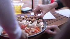 two people are serving themselves food on a plate