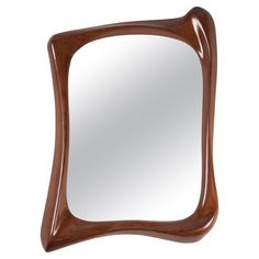 a wooden frame mirror sitting on top of a white wall