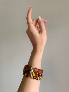 "Vintage 1940's statement signed Napier bracelet. Gold tone bracelet with amber, brown, and bright orange rhinestone crystals. Rhinestones are oval, circle, baguette, emerald, and tear drop cut. Bracelet in excellent condition with minor wear due to age. High quality and high shine rhinestones. Measurements Length: 6-3/4\" / Width: 1-1/2\" / Unless otherwise stated all vintage items are used and may have minor to moderate wear or discoloration considering the age of the item. Most items have bee Vintage Amber Bangle Bracelet, Vintage Amber Rectangular Jewelry, Brown Rectangular Metal Jewelry, Rectangular Brown Metal Jewelry, Vintage Orange Metal Jewelry, Elegant Orange Jewelry With Stones, Retro Orange Jewelry For Party, Adjustable Vintage Amber Jewelry, Luxury Orange Jeweled Jewelry As Gift