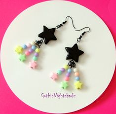 MADE TO ORDER!     Here we have some awesome Cute Earrings.  The Shooting Stars consist of a Black Star and three shooting stars per earring.  Shooting stars are made up of round and star pastel beads.  They hang on black Hypoallergenic ear hooks and the drop length is approximately 8cm.  These Kawaii Earrings would make a Great Gift for someone special or for yourself! Handmade, and will be packaged in a pretty organza gift bag. Visit my shop to see the complete collection of Pastel Goth Jewell Pastel Goth Choker, Pastel Goth Earrings, Studio Ghibli Earrings, Wicca Necklace, Goth Jewellery, Star Fairy, Goth Choker, Pastel Kawaii, Goth Necklace