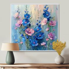 an abstract painting with blue, pink and white flowers on the wall next to a lamp