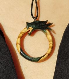 This is a 100% handmade Resin & Stabilized Olive Wooden necklace. I'm proud to have this handmade necklace in my shop. This Ouroboros Dragon pendant will make a perfect unique gift for Christmas, i will send it in a nice gift box. This necklace is made of Resin & Stabilized Wood and completely handcrafted. Every detail is carefully handcarved. Cord is adjustable Ready and packed for shipping, what you see is exactly what you get. Please contact me for custom order. Hand Painted Spiritual Round Necklaces, Unique Personalized Round Pendant Necklaces, Collectible Carved Pendant Necklace, Carved Pendant Necklace Collectible, Artisan Jewelry With Lobster Clasp As Gift, Artisan Jewelry With Lobster Clasp For Gift, Handmade Symbolic Round Pendant Jewelry, Amulet Pendant Necklace As Gift, Amulet Style Round Pendant Necklace As Gift