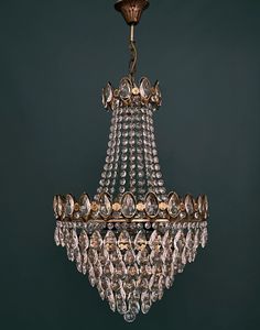 a chandelier hanging from the ceiling in a room with dark green walls and flooring