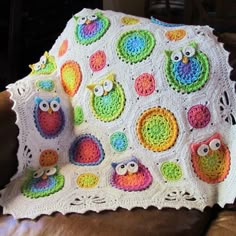 an owl themed crocheted blanket on a couch