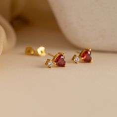 Indulge in the captivating allure of our Garnet Heart Drop Studs, your new go-to choice for romantic evenings and special occasions. Crafted with deep red, heart-shaped garnet gemstones, these exquisite earrings effortlessly radiate femininity and elegance, complementing any outfit with their timeless charm ♡ Material: High Quality Solid 925 Sterling Silver Finish: 18K Gold ∙ Sterling Silver Featuring ~7mm CZ Garnet Heart Charm with ~4.5mm CZ Diamond Drop Stud Earrings Sold as a pair Model showc Initial Tag Necklace, Garnet Heart, Heart Shaped Earrings, Romantic Evening, Bar Bracelets, Color Rojo, Diamond Drops, Heart Studs, Garnet Gemstone