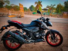 a black and red motorcycle parked in the dirt