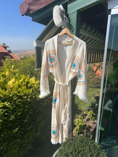 "Beautiful handmade white evil eye kimono robe or/and towel, sarong designed with cotton fabric, it flows as you move for comfortable wear. Beach cover-up, a kimono with an evil eye design.   This is a lovely, good-quality kimono, with traditional breathable kimono sleeves.        A belt that ties around the waist. Great to wear around the house, on beaches, or to dress up with some jeans & a T-shirt, covering up on the beach with a swimsuit.   Please choose a kimono, sarong, or set options depends what you would like to have :)      We love kimonos as they are so versatile. They also make really special & unique birthday, valentines Day, Christmas gifts, and Mother's Day gifts. The perfect combination of comfort and style, this kimono is a great addition to your new season wardrobe.    Co White Cotton Kimono For The Beach, White Open Front Kimono For Festival, White Cotton Kimono For Vacation, White Robe With Kimono Sleeves For The Beach, White Wrap Robe For Vacation, White Hippie Kimono For Spring, Long Beige Kimono For Festival, Beige Long Kimono For Festival, White Robe With Kimono Sleeves For Beach Cover-up