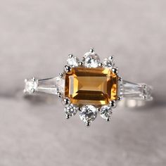 ◆ The ring is handcrafted from sterling silver and decorated with a dazzling 5*7 mm Citrine and CZs. It is suitable for engagement/anniversary/daily occasion. ◆ Production Description: Main stone Type: Natural Citrine Main Stone Shape: Emerald Cut Main Stone Size: 5*7 mm(1.01ct) Side stone: CZ Metal: 925 Sterling silver - Other options available in the drop down menu ◆ Customization: √Free for Add Engraving √Other Metal Type Available √Other Gemstones & Shapes Available √Personalization Requ Wedding Rings With Citrine In Baguette Cut, Citrine Baguette Cut Wedding Rings, Baguette Cut Citrine Wedding Rings, Elegant Diamond Ring With Citrine Center Stone, Elegant Citrine Diamond Ring With Center Stone, Wedding Topaz Ring With Baguette Cut, Elegant Citrine Birthstone Ring For Formal Occasions, Elegant Citrine Birthstone Ring For Formal Events, Baguette Cut Topaz Ring For Wedding