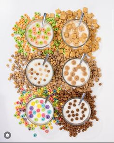 cereal, milk, and cereal bars are arranged on a white surface with spoons