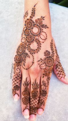 a woman's hand with henna tattoos on it