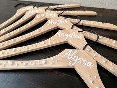 wooden clothes hangers with names on them sitting on top of a black countertop